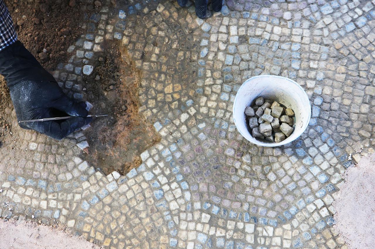 A worker examines a mosaic floor at Stratonikeia Ancient City in Muğla, Türkiye, June 8, 2026. (AA Photo)