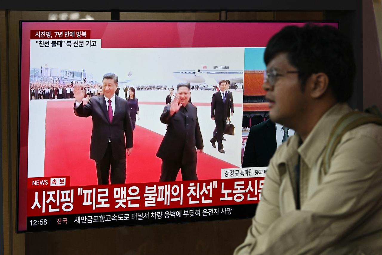 A man walks past a television screen showing a news broadcast with file footage of the 2019 meeting between China's President Xi Jinping and North Korean leader Kim Jong Un, at a train station in Seoul, South Korea, June 8, 2026. (AFP Photo)