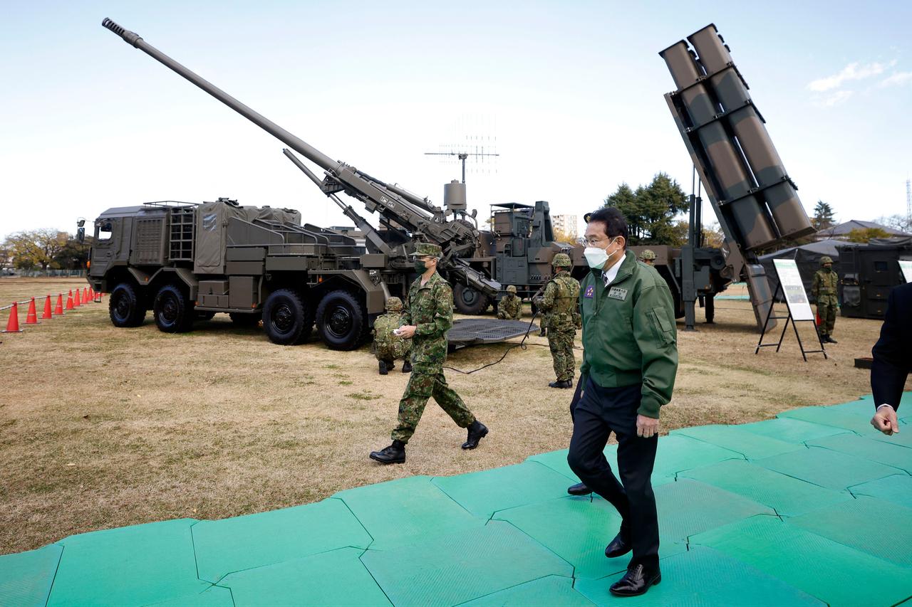 Japan's Prime Minister Fumio Kishida (2nd-L) walks past a Japan Ground Self-Defense Force (JGSDF) Type 19 155 mm wheeled self-propelled howitzer (back-L) and a Type 12 surface-to-ship missile (back-R) as he inspects equipments during a review at JGSDF Camp Asaka in Tokyo, Japan, November 27, 2021. (AFP Photo)
