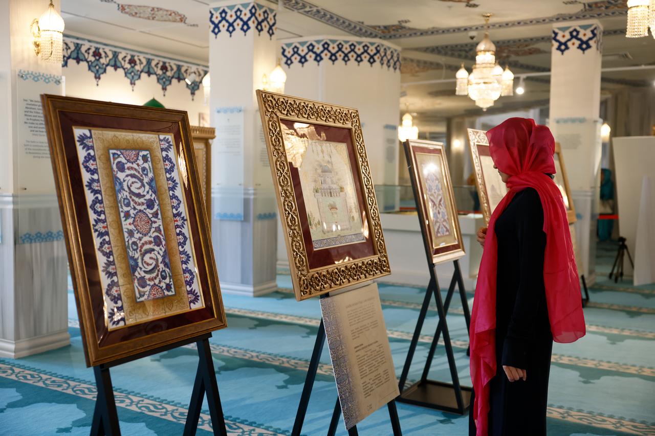 A visitor examines framed illumination and miniature works inspired by Ottoman mosques at Moscow Central Mosque in Russia. (AA Photo)