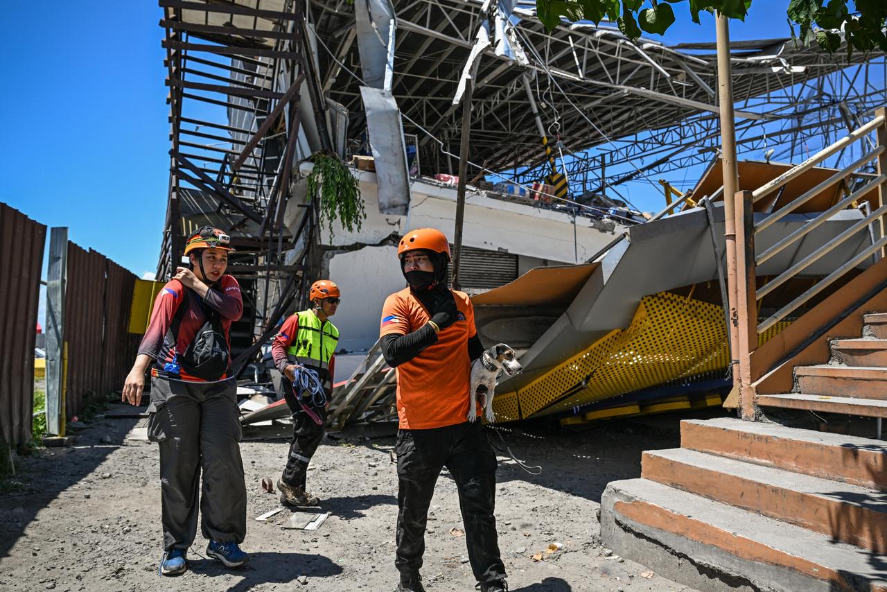 Responders and a rescue dog conduct search and rescue operations at the site of a collapsed building after a 7.8 magnitude earthquake in General Santos City, Philippines, June 9, 2026. (AFP Photo)