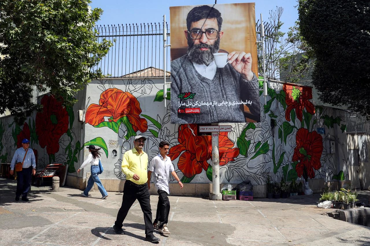 People walk past a mourning billboard depicting Iran's slain supreme leader Ali Khamenei, who was killed in a strike on the first day of the US-Israeli war against Iran on February 28, in Tehran on June 30, 2026. (AFP Photo)