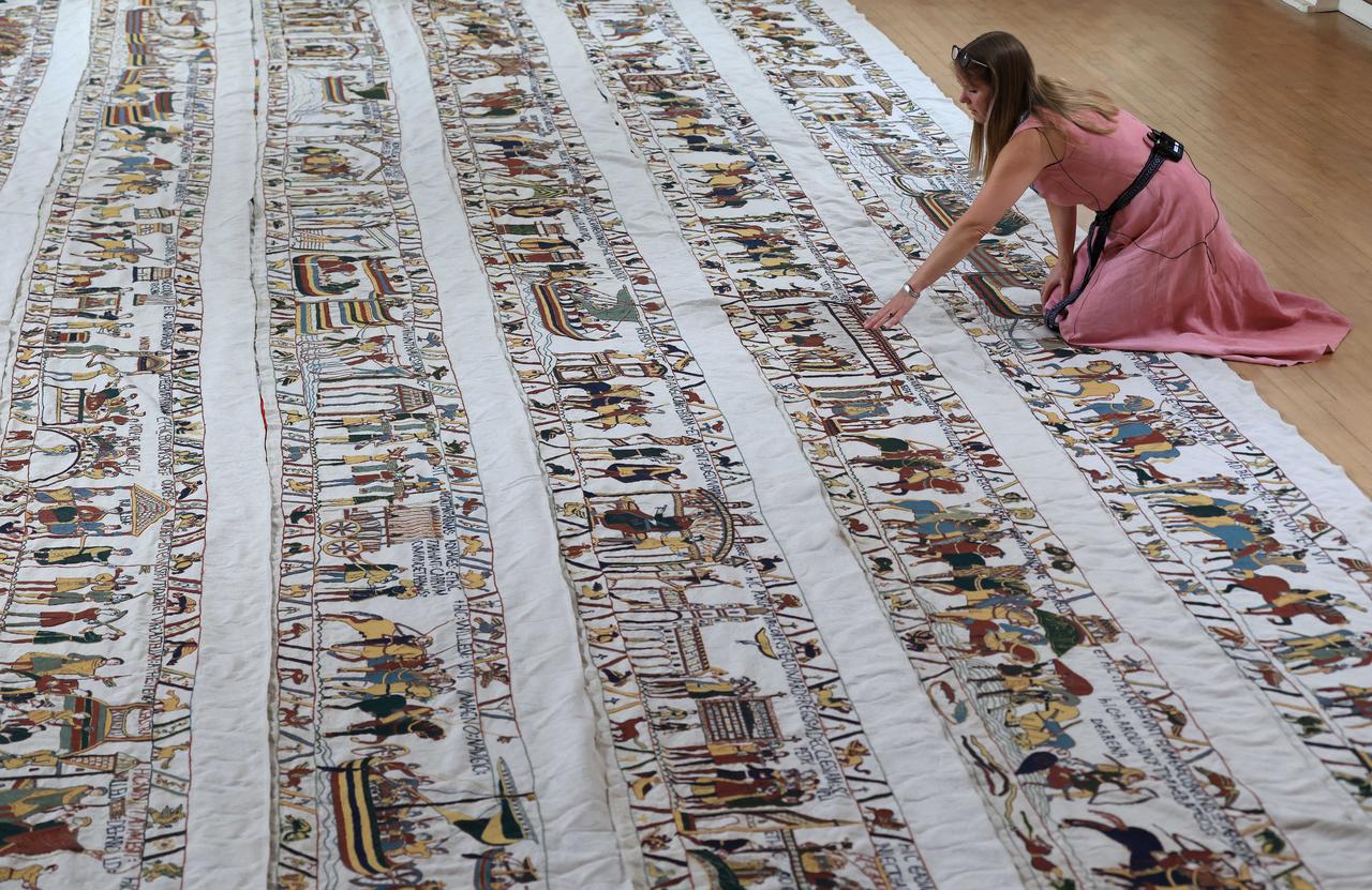Mia Hansson sets up a large replica of the Bayeux Tapestry, which has been recreated step by step by the former teacher, at a hall in Wisbech, eastern England on July 1, 2026. (AFP Photo)