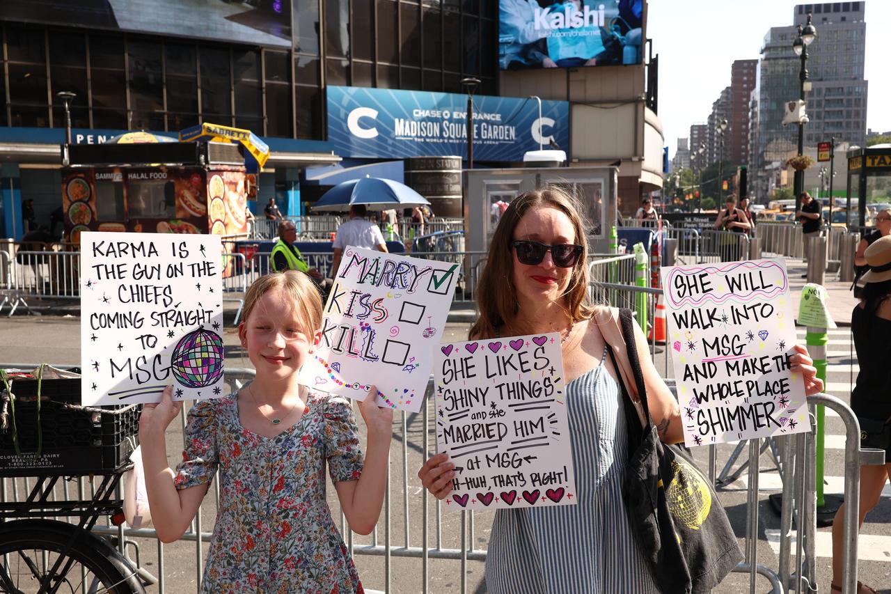 Taylor Swift fans hold signs outside Madison Square Garden, the reported venue for the wedding celebrations. (AFP Photo)