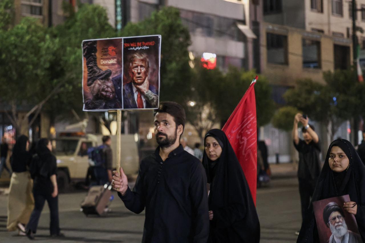 A man holds an anti-US placard as he arrives with others to attend the funeral of slain Iranian leader Ali Khamenei in Mashhad, July 9, 2026. (AFP Photo)