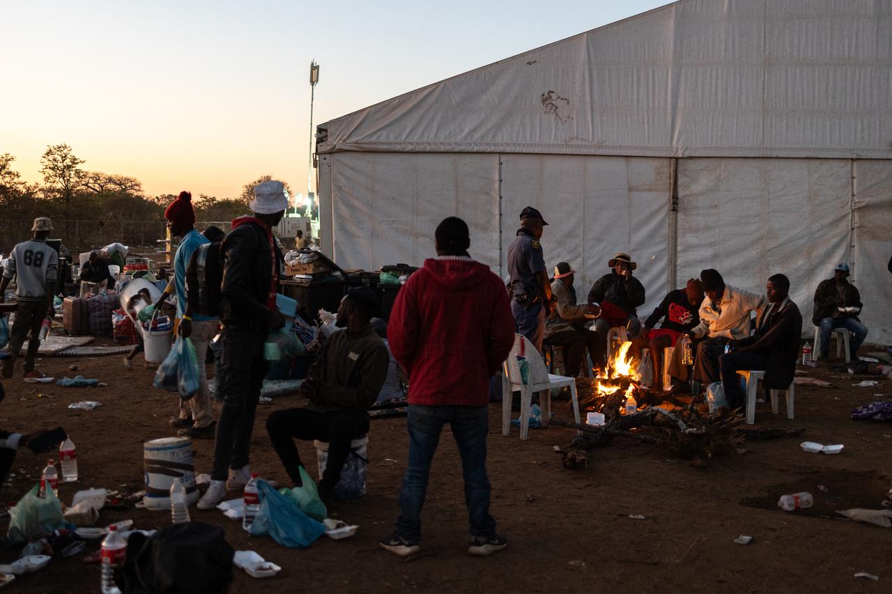 People awaiting repatriation gather outside of a dormitory tent in a repatriation centre in Musina, near the Beitbridge border crossing with Zimbabwe, on July 8, 2026. (AFP Photo)