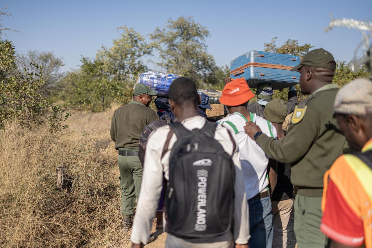 Border Management Authority (BMA) officers escort detained individuals during a patrol along the South Africa-Zimbabwe border on July 9, 2026. (AFP Photo)