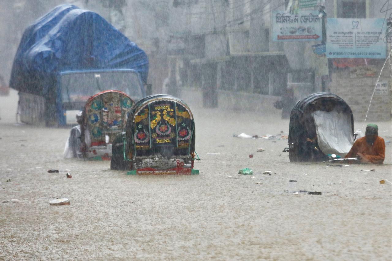 Rickshaw pullers wade through a flooded street after heavy rains in Chittagong, China, July 8, 2026. (AFP Photo)