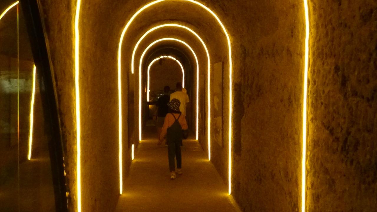 Visitors walk through an illuminated corridor at the Kars Cheese Museum in Kars, eastern Türkiye. (IHA Photo)
