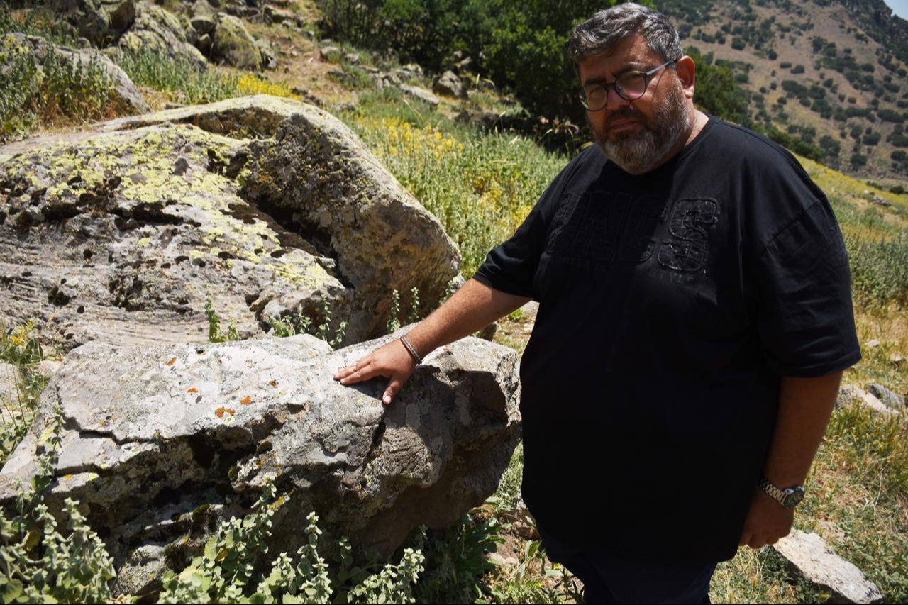 Associate Professor Ilker Mete Mimiroglu examines the rock block bearing runic markings during surface surveys at Binbirkilise, a Byzantine-era site known for its church ruins in Karaman, central Türkiye. (AA Photo)