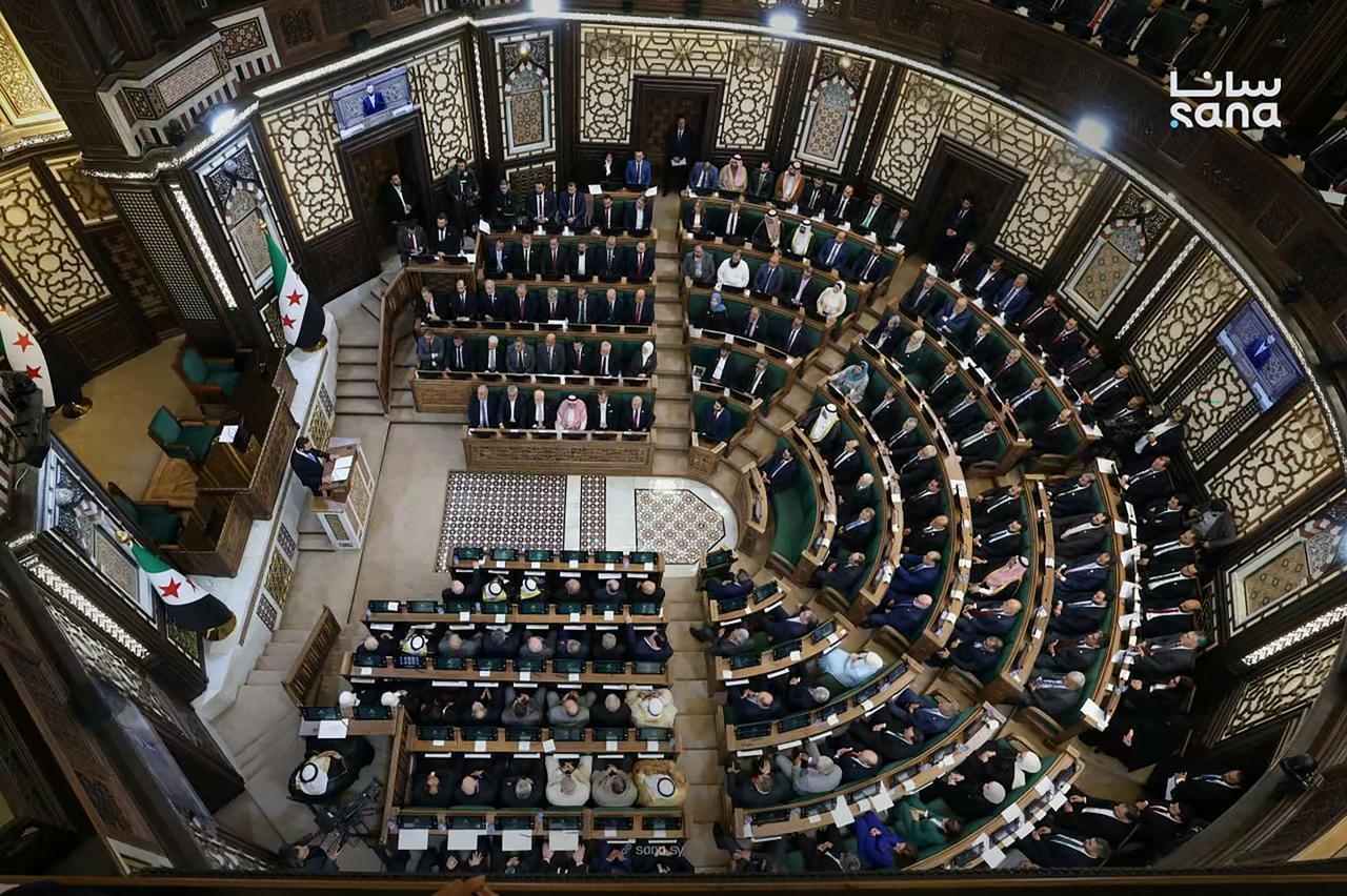 This handout picture taken and released by the official Syrian Arab News Agency (SANA) on July 12, 2026 shows Syria's President Ahmed al-Sharaa (L) speaking during the first meeting of Syria's new transitional parliament in Damascus. (Photo by SANA/AFP)
