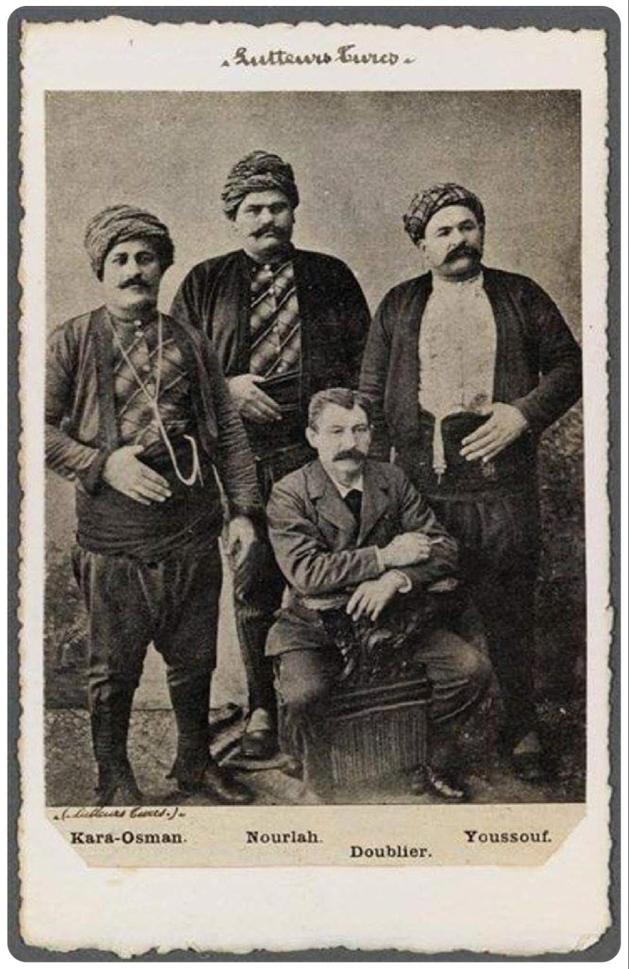 A late-19th-century photograph shows renowned Ottoman wrestlers Kara Osman, Filiz Nurullah and Koca Yusuf alongside their promoter, Doublier. (Photo via Facebook/Eskilerden Türkiye Fotograflari)