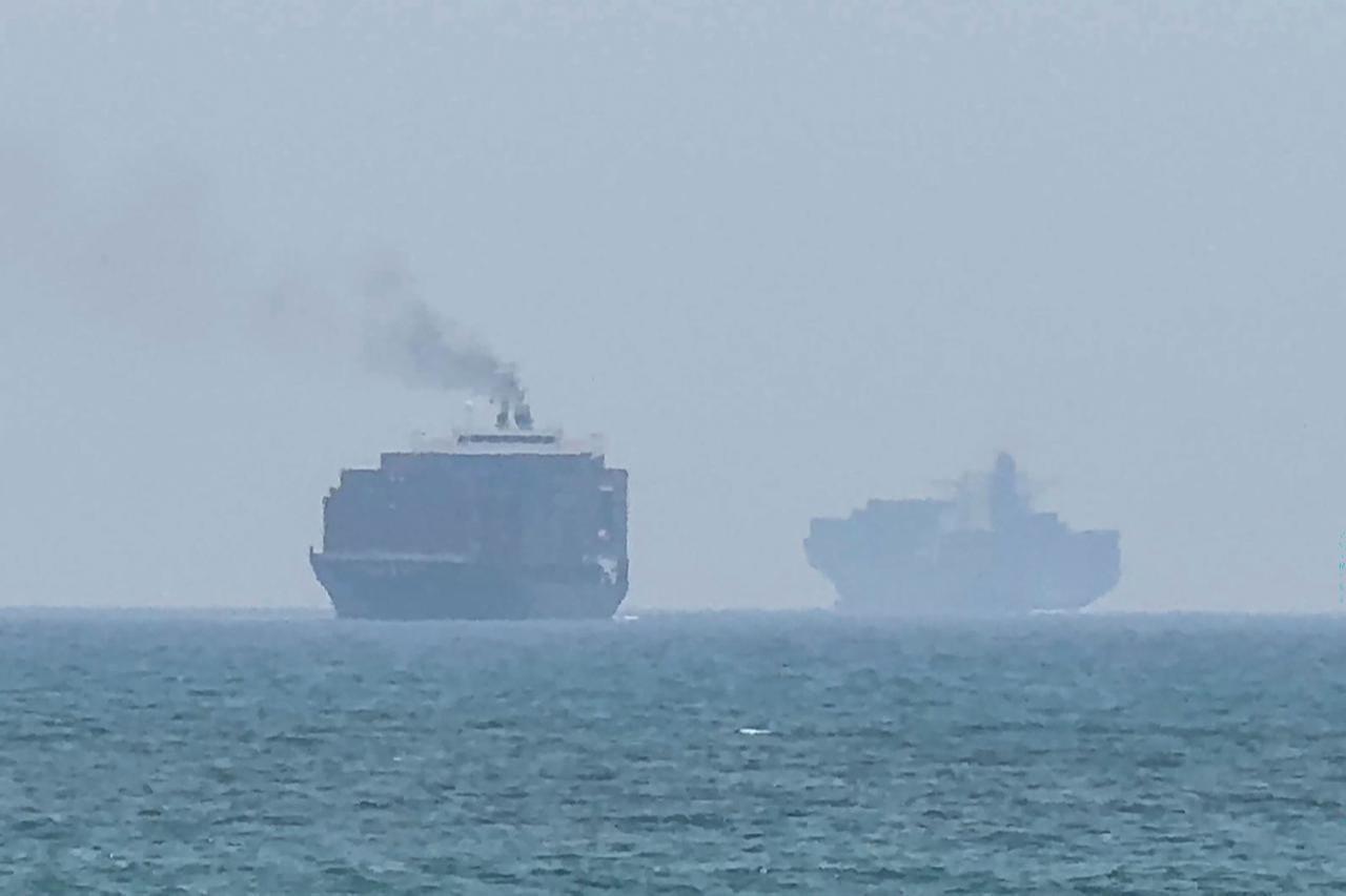 This frame grab taken from AFPTV video footage on July 12, 2026 shows cargo ships anchoring near the Strait of Hormuz off the eastern coast of the United Arab Emirates at Khor Fakkan. (AFP Photo)