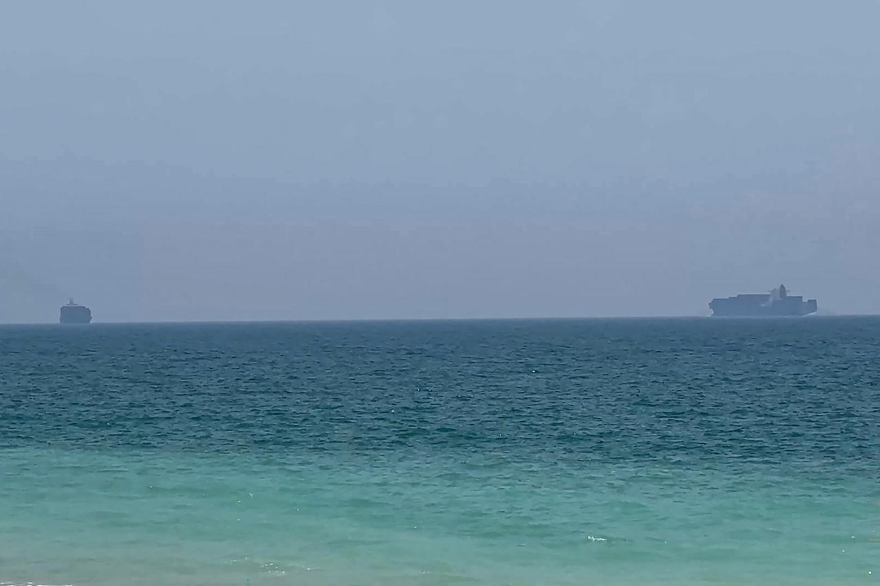 This frame grab taken from AFPTV video footage on July 12, 2026 shows cargo ships anchoring near the Strait of Hormuz off the eastern coast of the United Arab Emirates at Khor Fakkan. (AFP Photo)