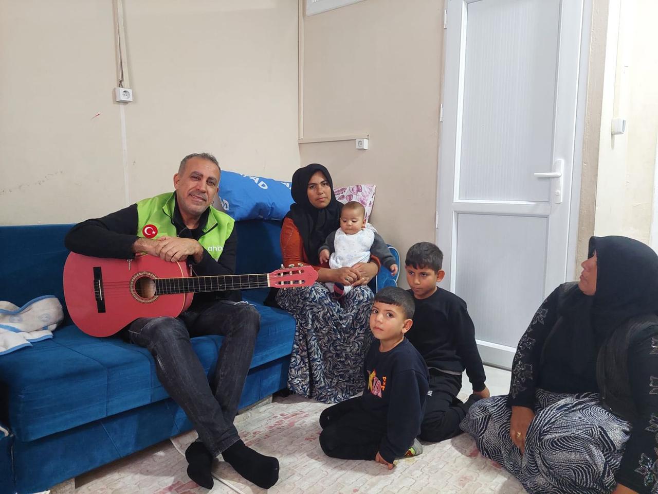 Turkish singer and Ahbap founder Haluk Levent visits earthquake survivor Mahi Davulcu and her children at a container settlement in Nurdagi, Türkiye, in a photo shared on Jan. 1, 2024. (Photo via X/@haluklevent)