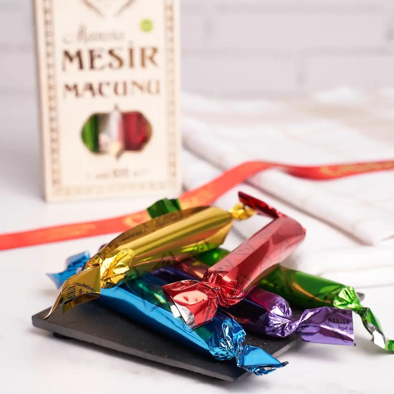 A packaged arrangement of traditional Manisa Mesir Macunu shows individual serving sticks encased in distinctive, brightly colored foil wrappers. (Adobe Stock Photo)
