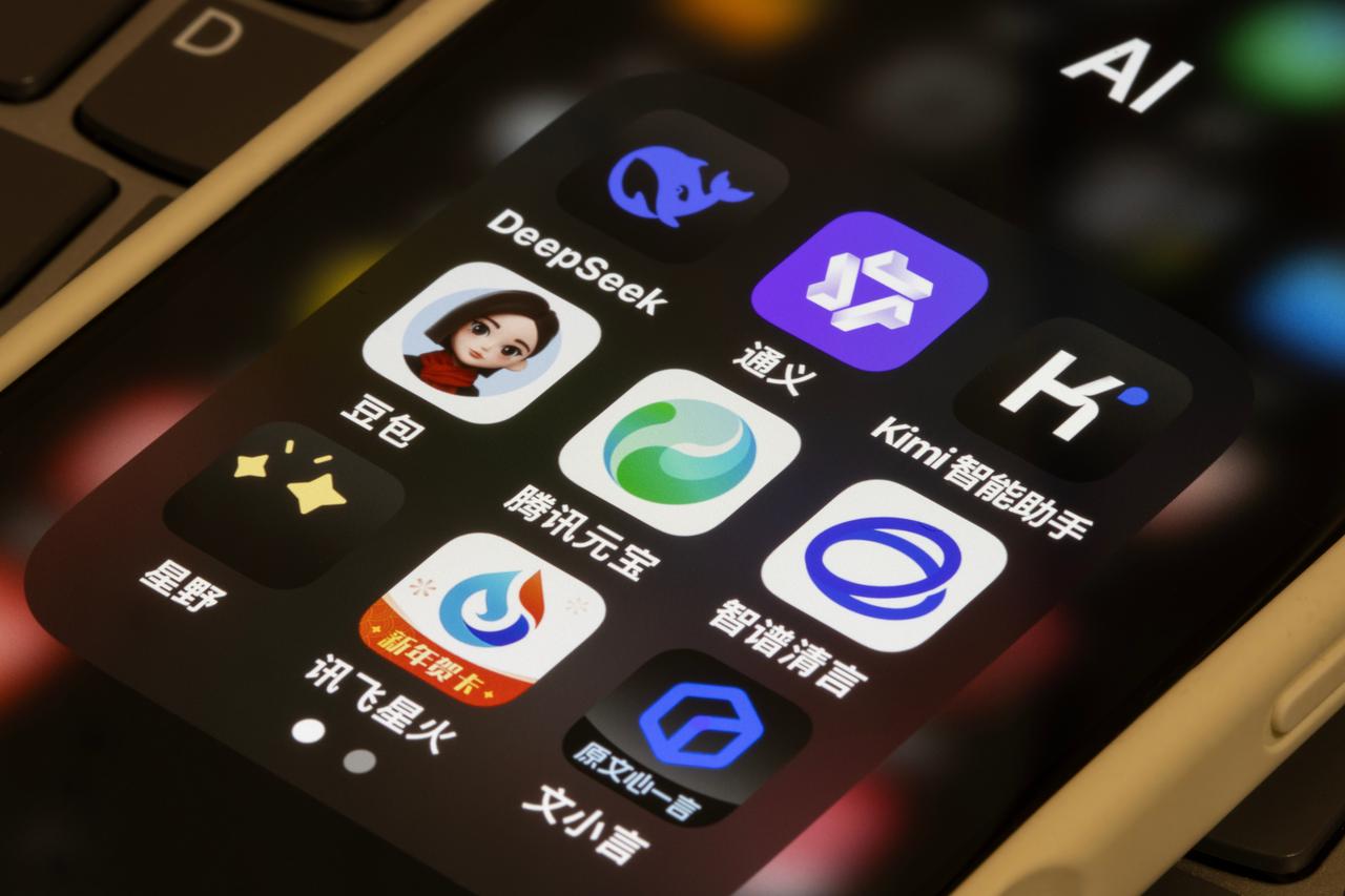 Various Chinese generative AI and chatbot application icons, including Doubao and Tencent Yuanbao, are pictured inside a designated "AI" folder on a mobile device. (Photo via Adobe Stock)