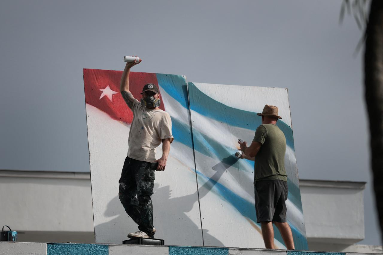 An artist painting a Cuban flag looks on during the Liberation Day Rally in Miami, Florida on July 11, 2026. (AFP Photo)