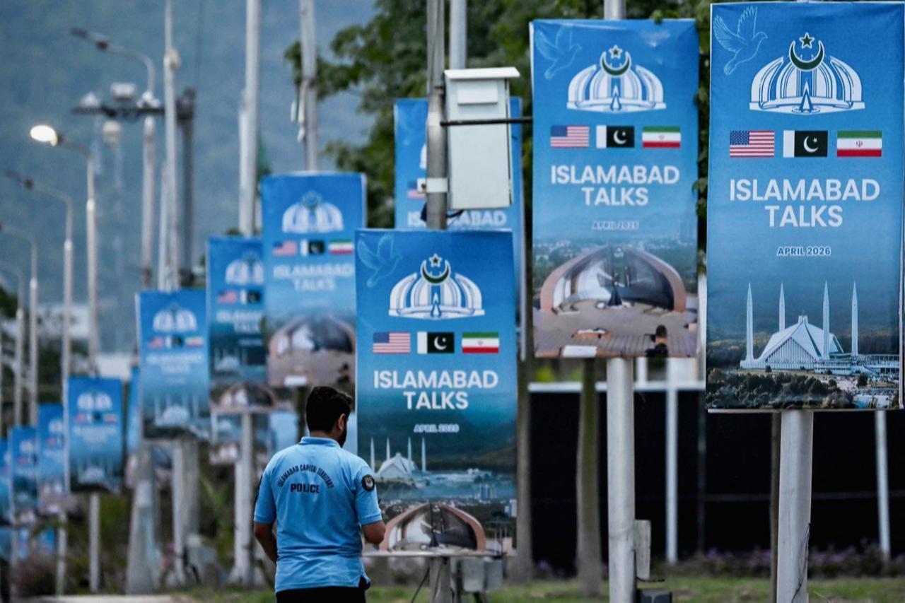 A police personnel walks past posters highlighting Pakistan's mediation of Iran–US peace talks, at the Red Zone area in Islamabad, Pakistan on April 18, 2026. (AFP Photo)