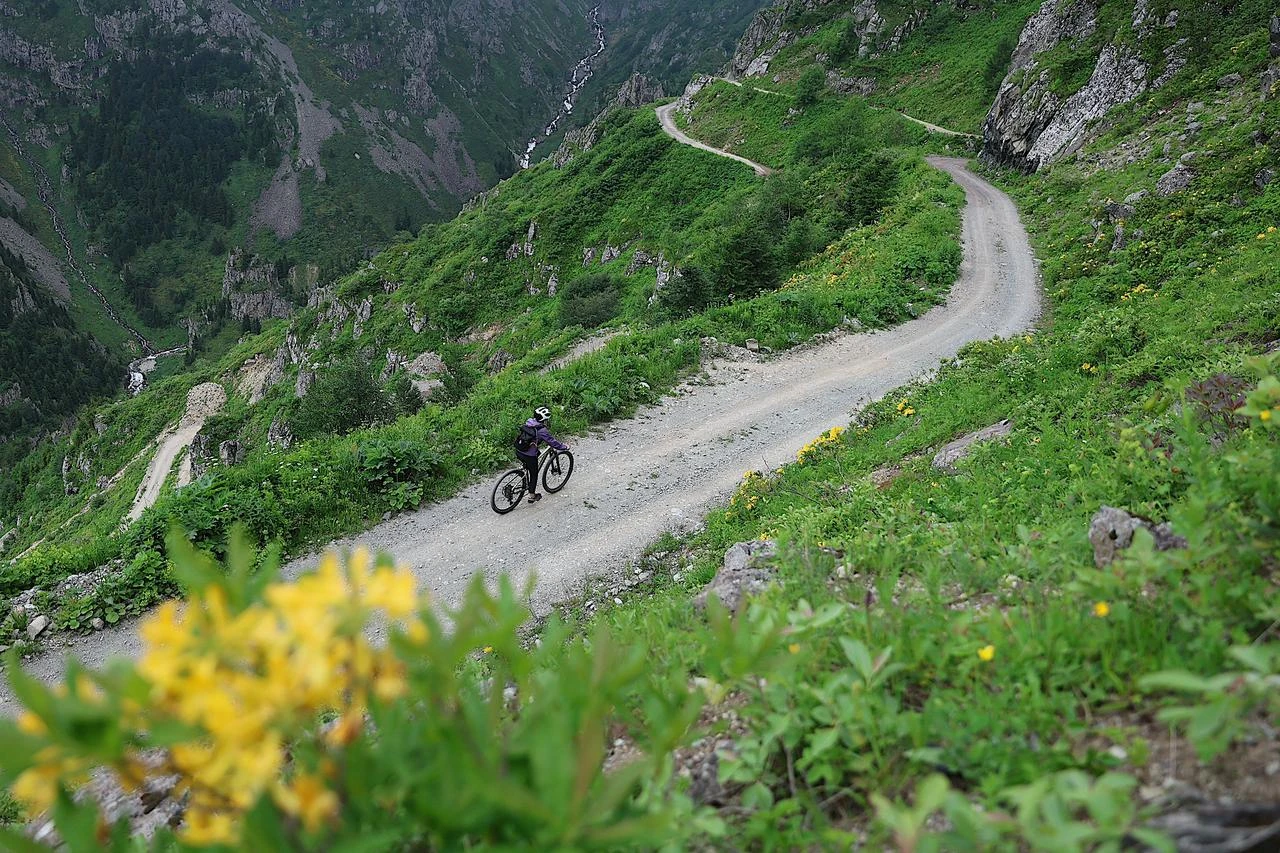 Biker navigates the narrow, unpaved mountain curves of the Derebasi pass by bicycle amid lush green terrain. (AAPhoto)