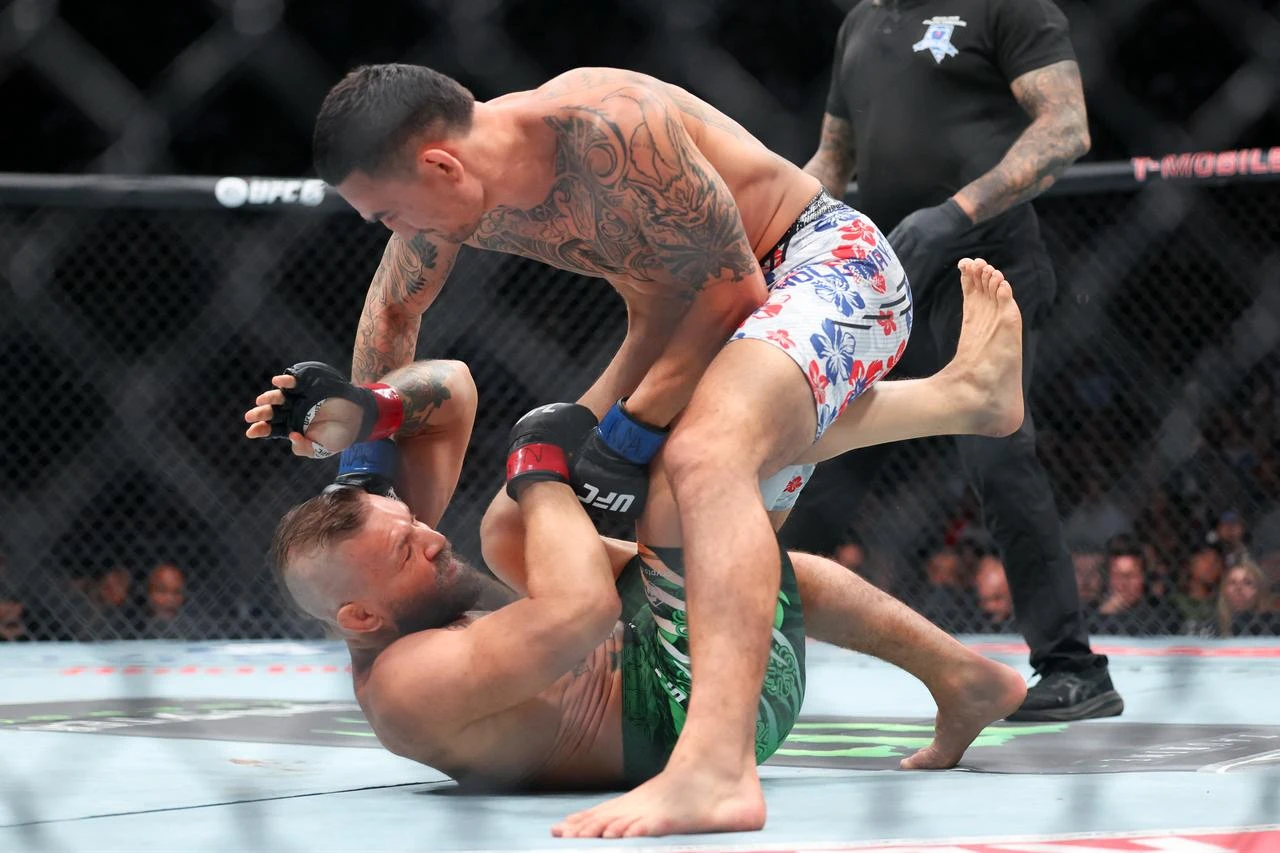 Max Holloway of the United States lands a punch on Conor McGregor of Ireland in their welterweight bout at T-Mobile Arena, in Las Vegas, Nevada, July 11, 2026. (AFP Photo)
