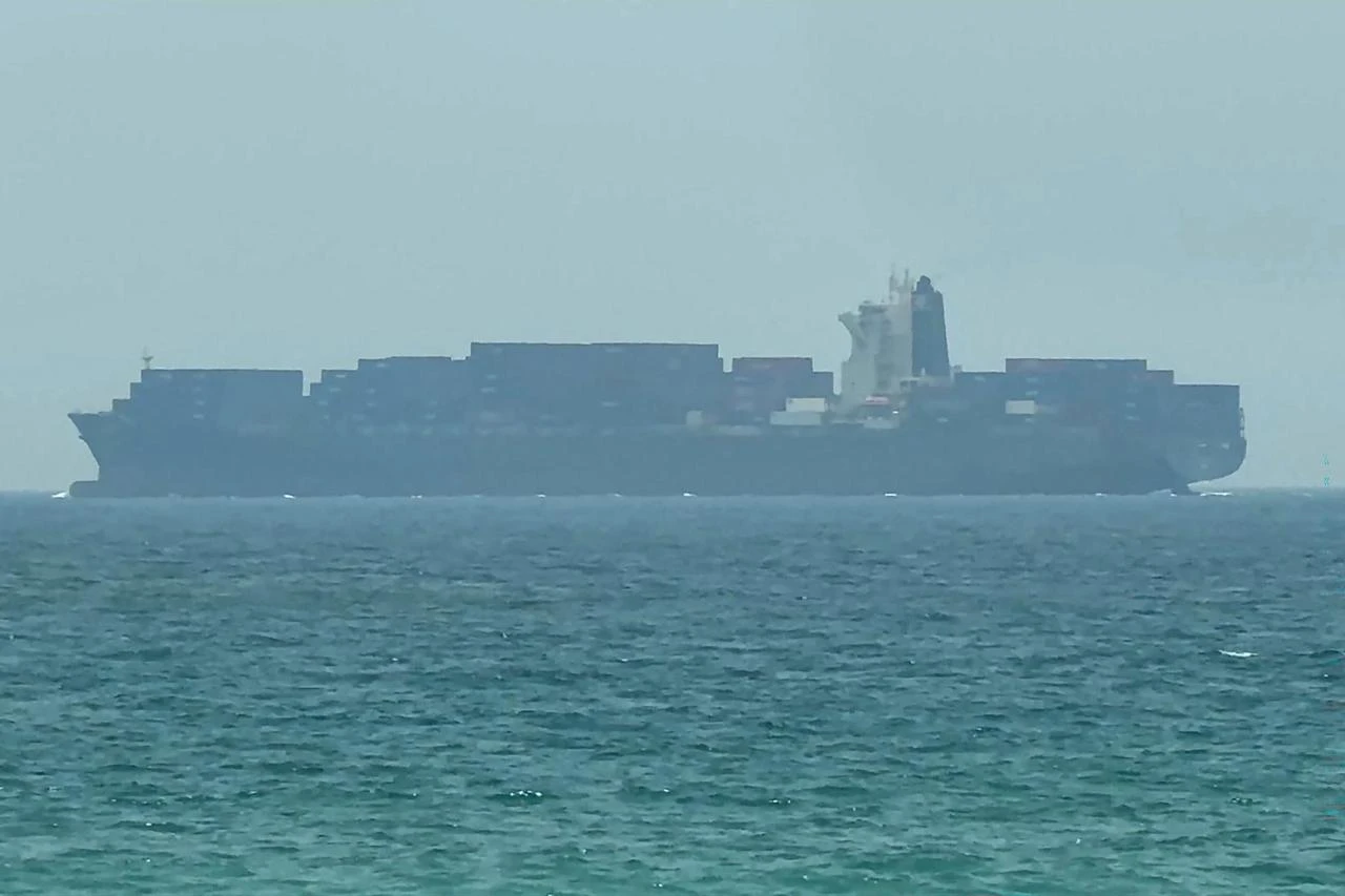 This frame grab taken from AFPTV video footage on July 12, 2026 shows a cargo ship anchoring near the Strait of Hormuz off the eastern coast of the United Arab Emirates at Khor Fakkan. (AFP Photo)