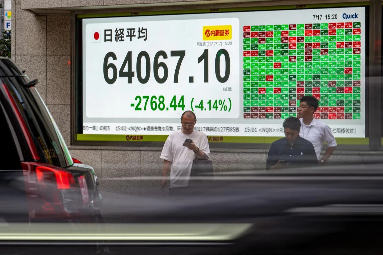 Pedestrians stand in front of an electronic quotation board displaying the Nikkei Stock Average on the Tokyo Stock Exchange in Tokyo, July 17, 2026. (AFP Photo)