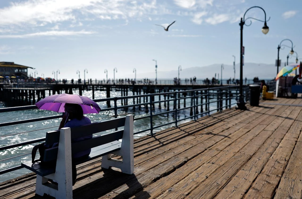 A person uses an umbrella at Santa Monica Pier amid a heat wave across Southern California, July 15, 2026. (AFP Photo)