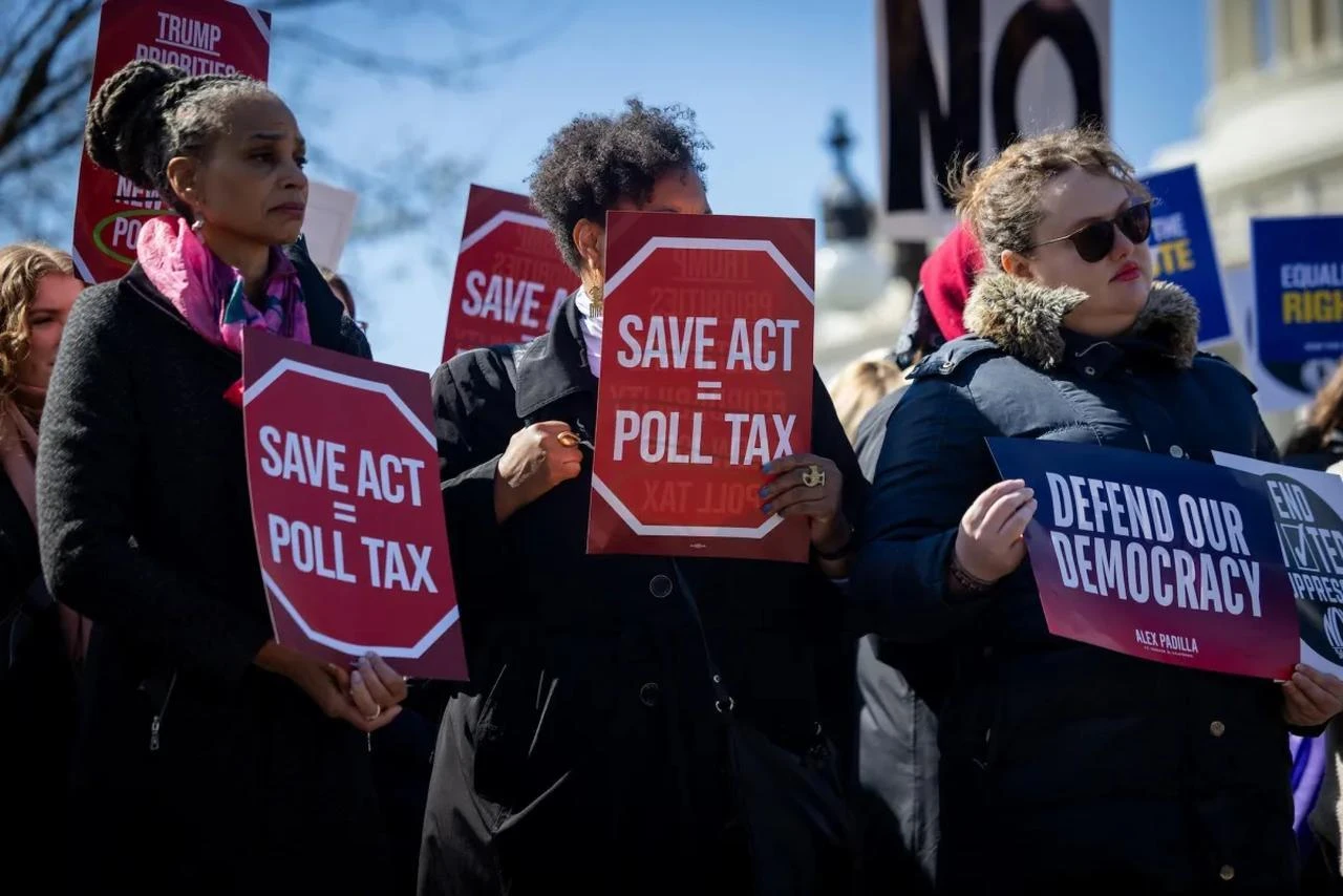 Attendees hold up signs during a rally against the SAVE America Act outside the U.S. Capitol in Washington on March 18. (AA Photos)