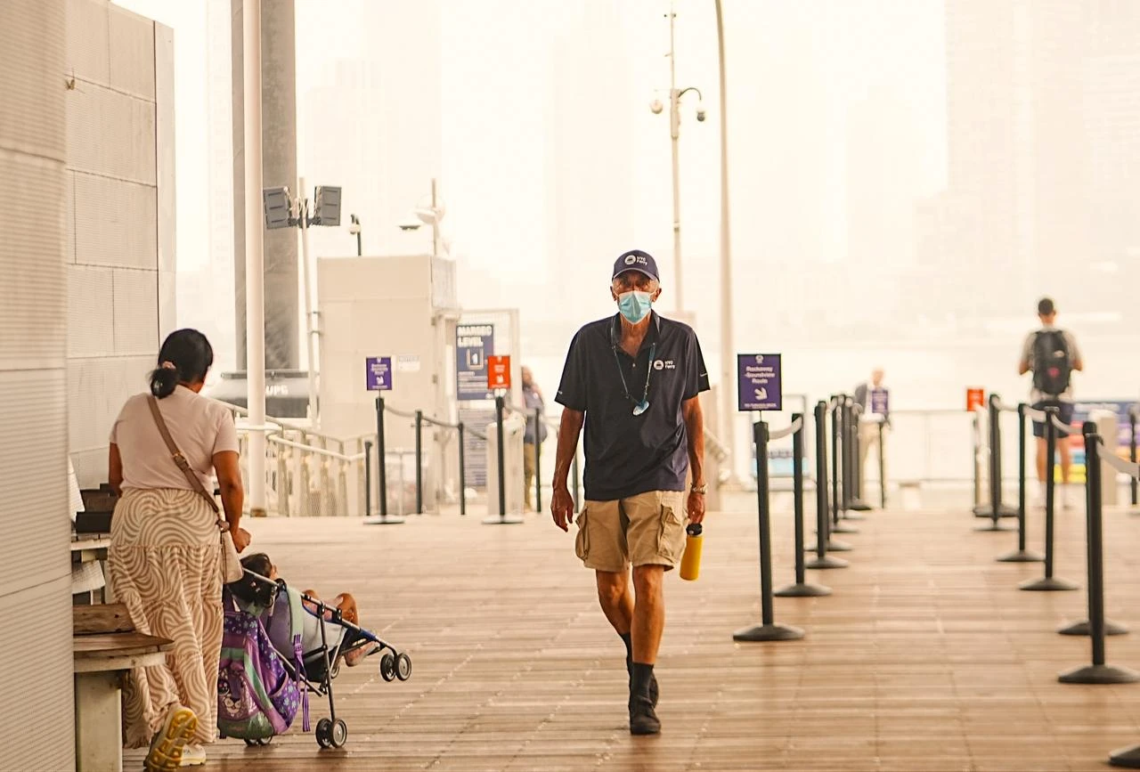 A man wearing a face mask walks through an NYC Ferry terminal as wildfire smoke from Canada blankets New York City, New York, U.S., July 17, 2026. (AA Photo)