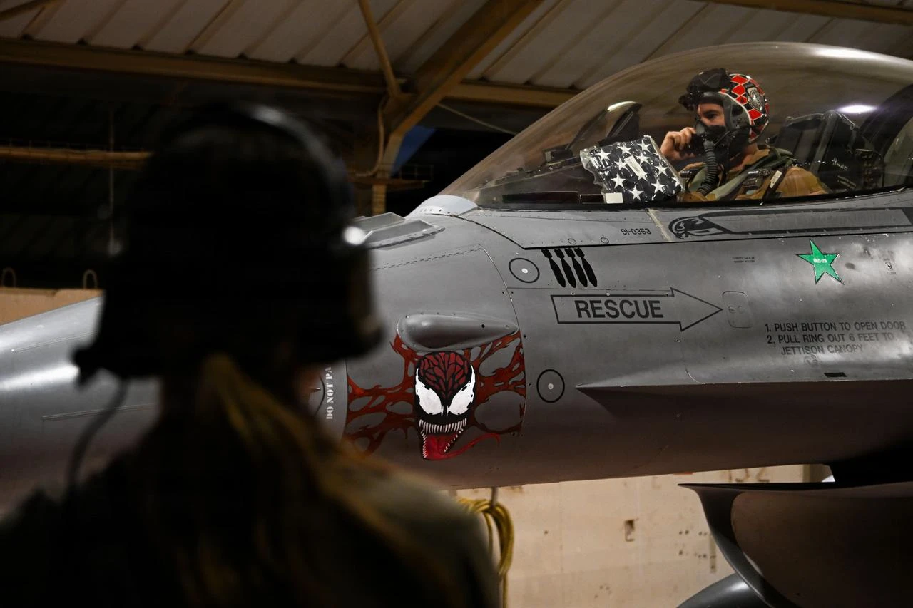 A U.S. Air Force crew chief assists a pilot with final preflight checks on a U.S. Air Force F-16 Fighting Falcon aircraft before taking off from a base in the U.S. Central Command area of responsibility June 16, 2026. (Photo via U.S. Air Force)