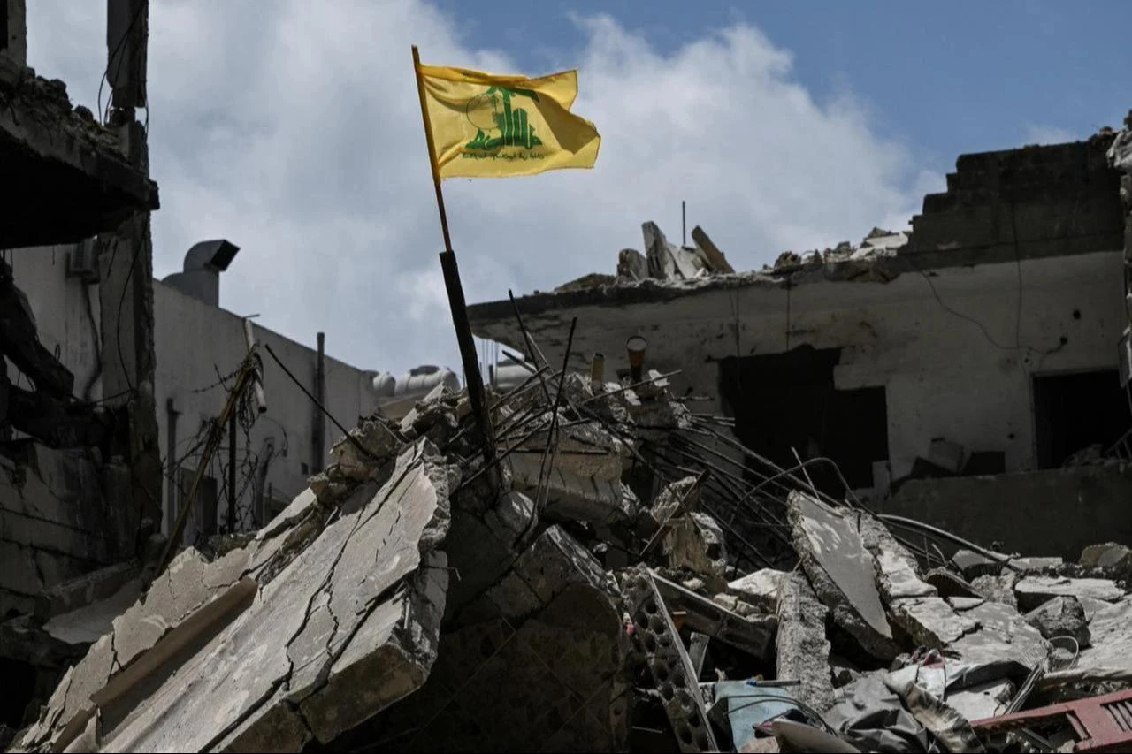 A yellow flag belonging to Hezbollah flutters on top of the rubble of a building in the southern Lebanese coastal city of Tyre, June 23, 2026. (AFP Photo)