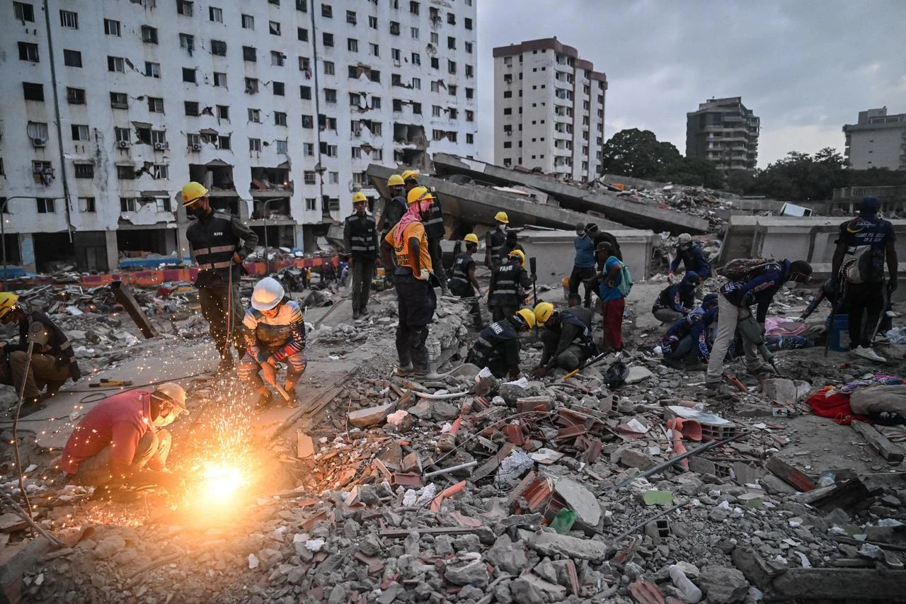 Volunteers and rescuers search for bodies amid debris of buildings damaged by the June 24 earthquakes, Venezuela, on July 18, 2026.(AFP Photo)