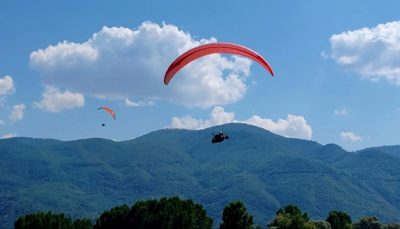 Paragliders fly over the mountains during the Yeşilay Paragliding Distance Türkiye Championship in Kütahya, Türkiye, July 18, 2026. (AA Photo)
