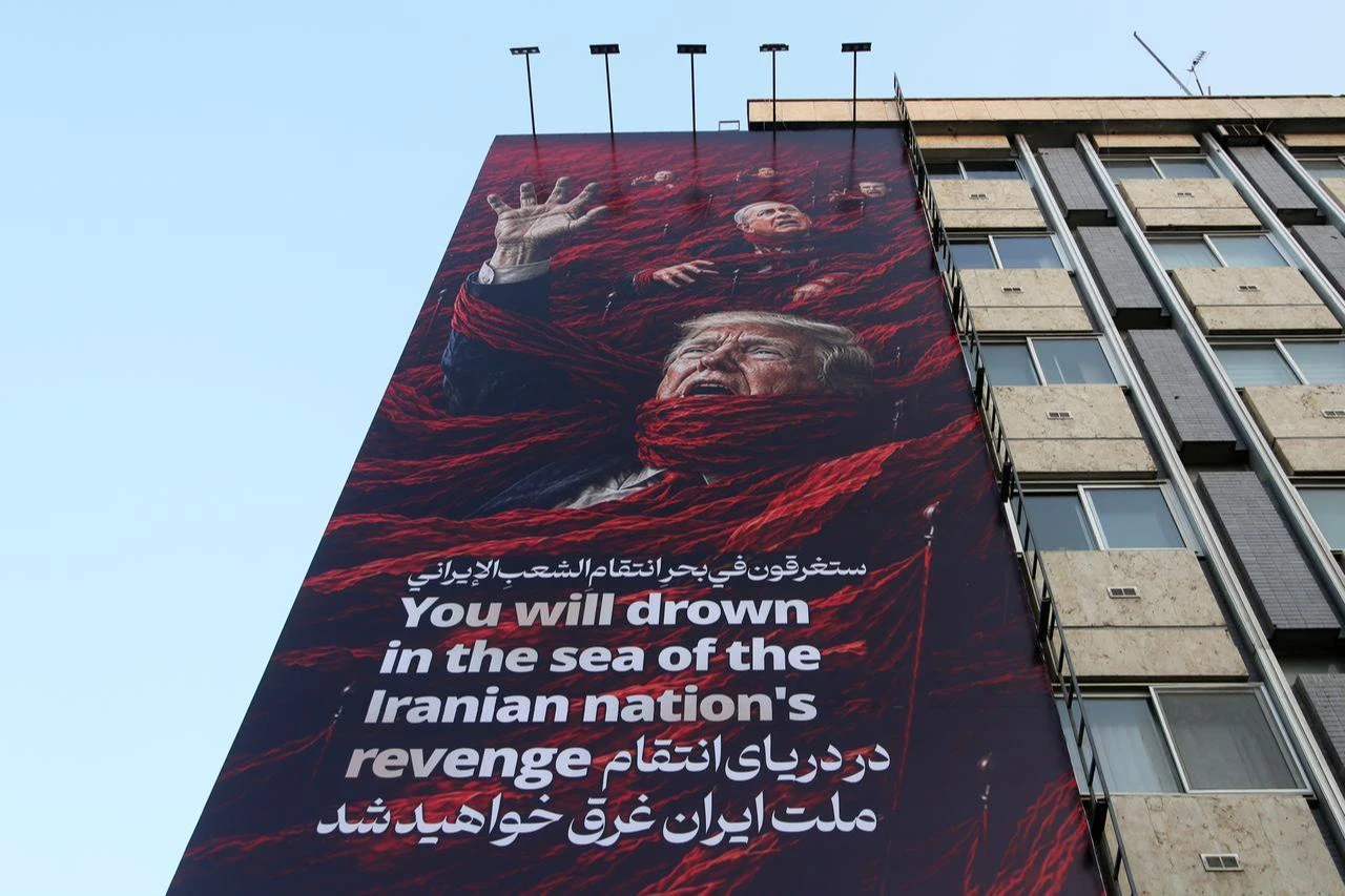 An anti-U.S. banner featuring the inscription "You will drown in the sea of the Iranian nation's revenge" is displayed on a building at Fatimi Square in Tehran, Iran, July 16, 2026. (AA Photo)