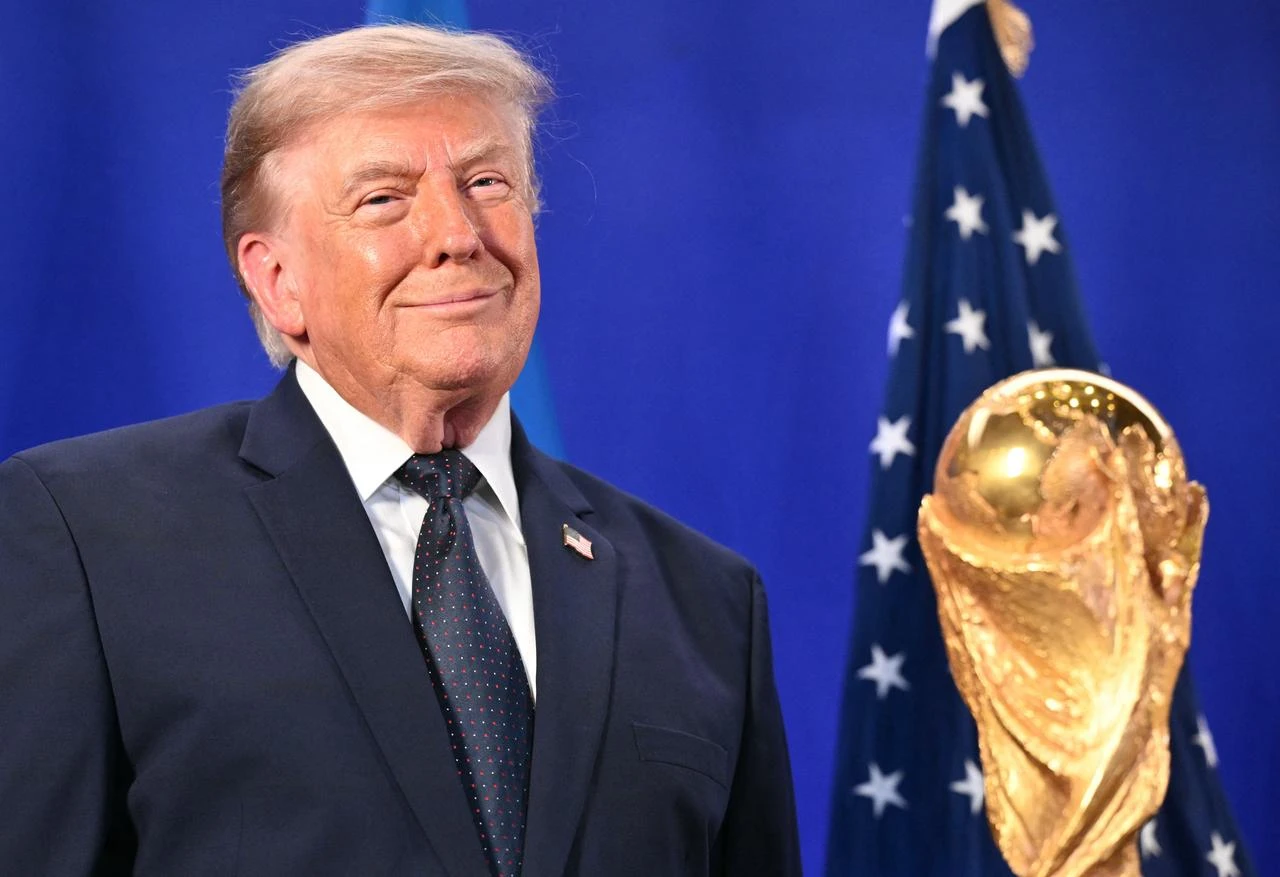 Trump stands by the FIFA World Cup Trophy as he listens to Gianni Infantino speak during a FIFA reception at Trump Tower in New York on July 17, 2026. (AFP Photo)