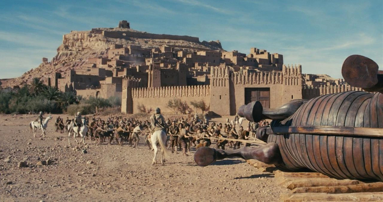 A production still from "The Odyssey" shows a large wooden horse structure in front of a fortified settlement. (Photo via IMDb)