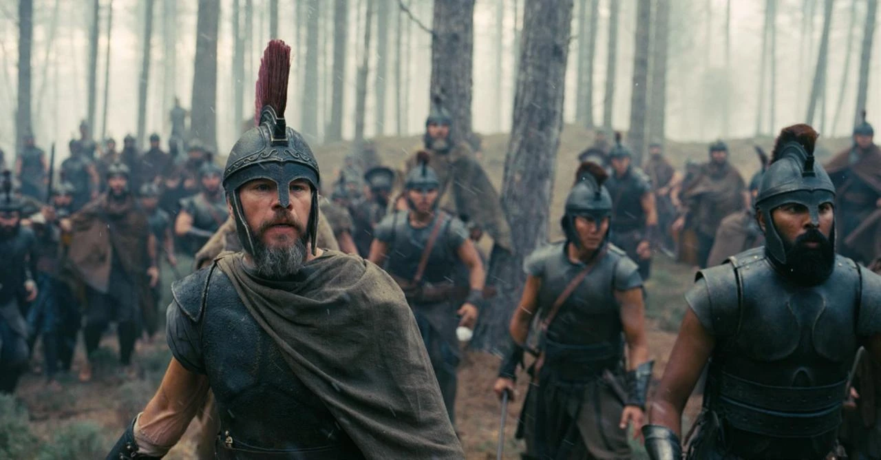 A battle scene from Christopher Nolan's "The Odyssey" shows armored warriors moving through a forest. (Photo via IMDb)
