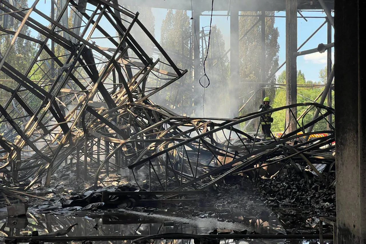 In this handout photograph taken and released by the Ukrainian Red Cross on July 2, 2026, a Ukrainian rescuer works among the debris of a destroyed Red Cross warehouse following an air attack in Kyiv, amid the Russian invasion of Ukraine. Red Cross said on July 2, 2026 that its key warehouse in Kyiv was "destroyed" by mass Russian overnight strikes, which burned down large amounts of humanitarian aid. (Photo by Handout / UKRAINIAN RED CROSS / AFP)