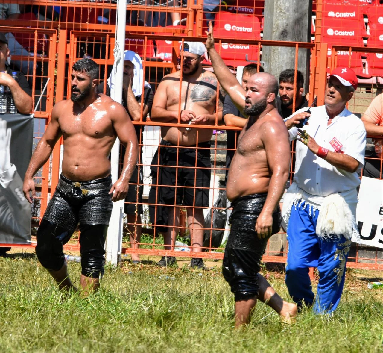 Oil wrestlers and an official walk along the field during the 2025 Historic Kirkpinar Oil Wrestling in Edirne, Türkiye. (IHA Photo)