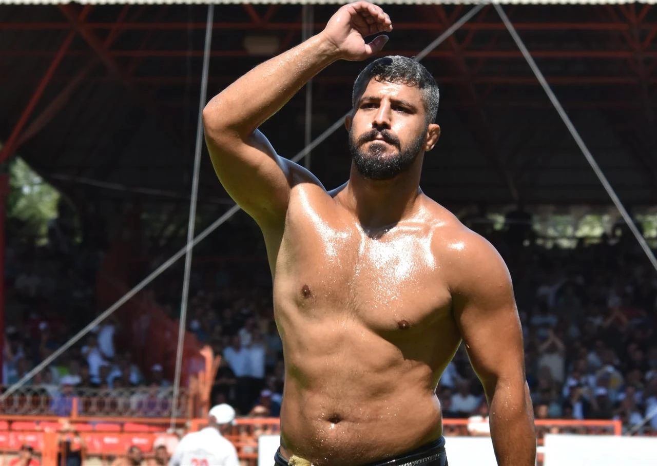 An oil wrestler salutes the crowd before competition during the 2025 Historic Kirkpinar Oil Wrestling in Edirne, Türkiye. (IHA Photo)