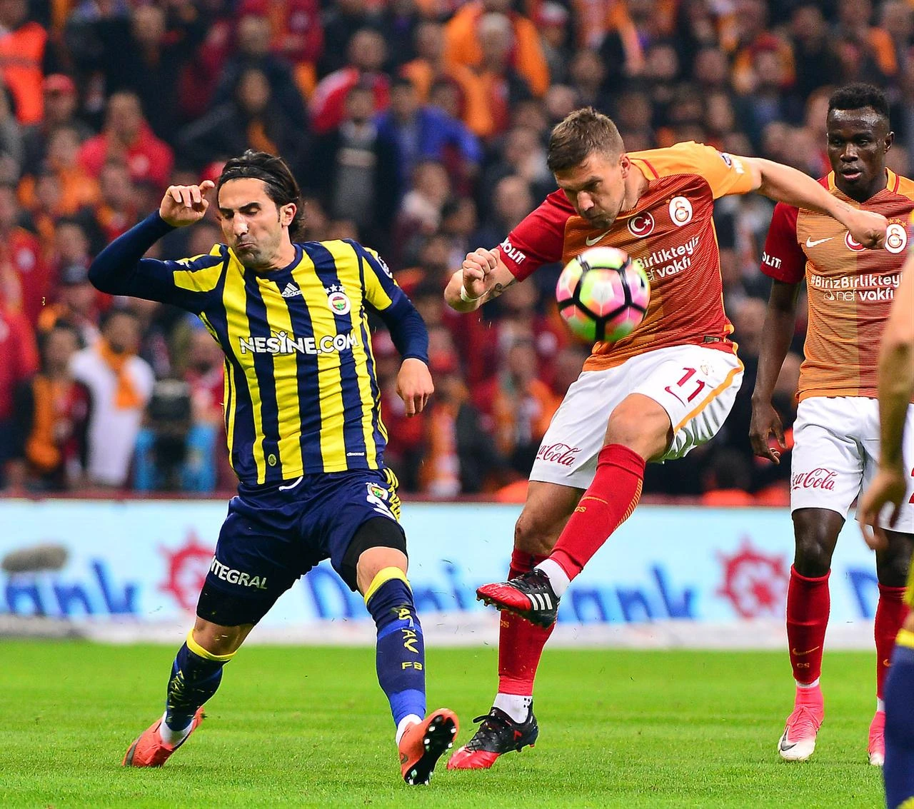 Galatasaray forward Lukas Podolski controls the ball under pressure from Fenerbahce left-back Hasan Ali Kaldirim during a Turkish Super Lig derby at Turk Telekom Arena in Istanbul, Türkiye, April 23, 2017. (IHA Photo)