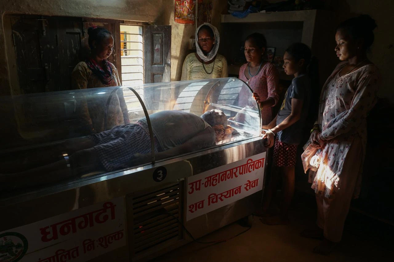 Relatives and neighbors mourn during funeral preparations in rural Nepal, where overseas migration can delay the return of family members for final rites. (Photo via Yam Kumari Kandel/GPJ Nepal)