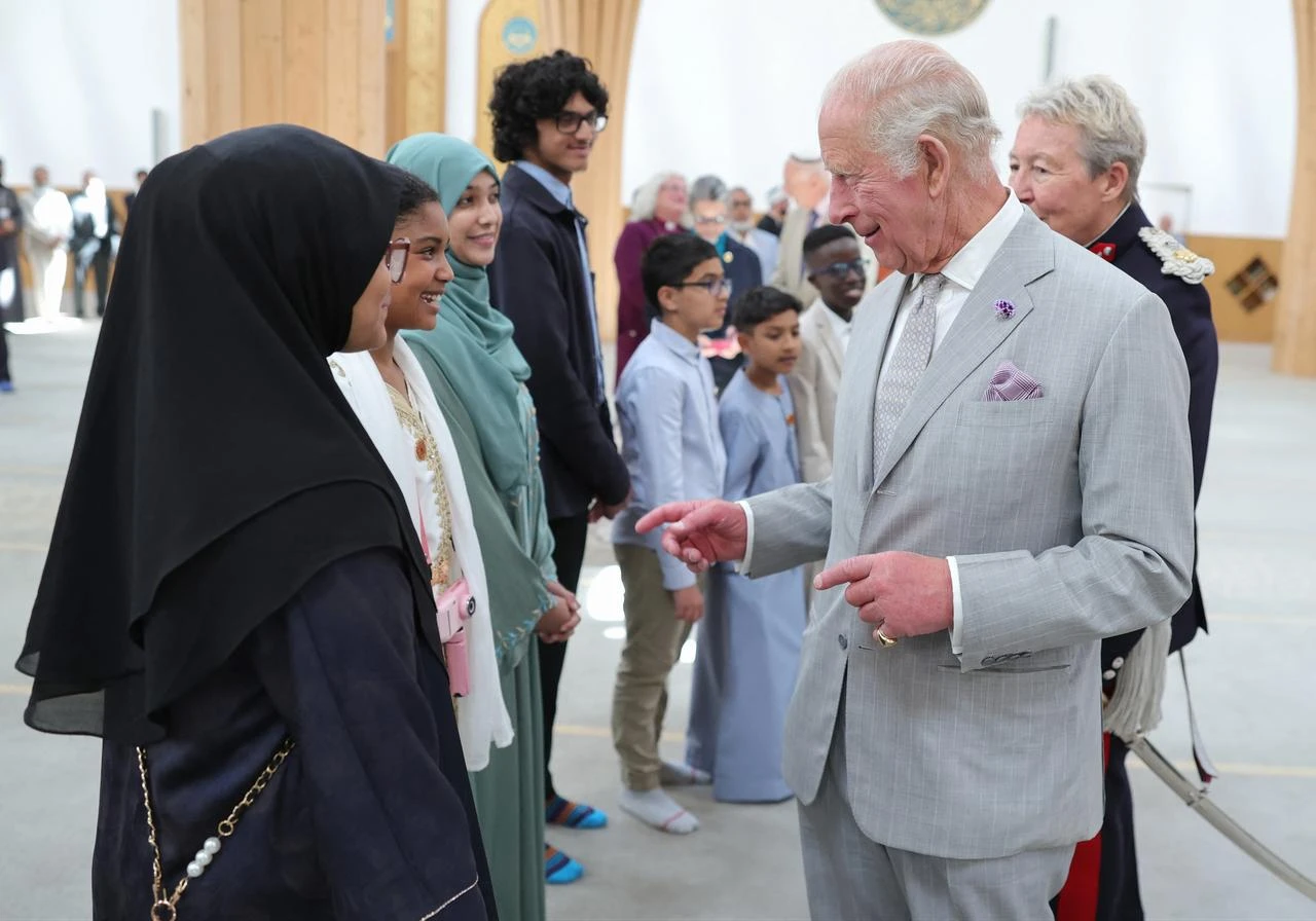 Britain's King Charles III smiles as he speaks with young people in the prayer hall during his visit to Cambridge Central Mosque in Cambridge, England, July 20, 2026 (AFP Photo)