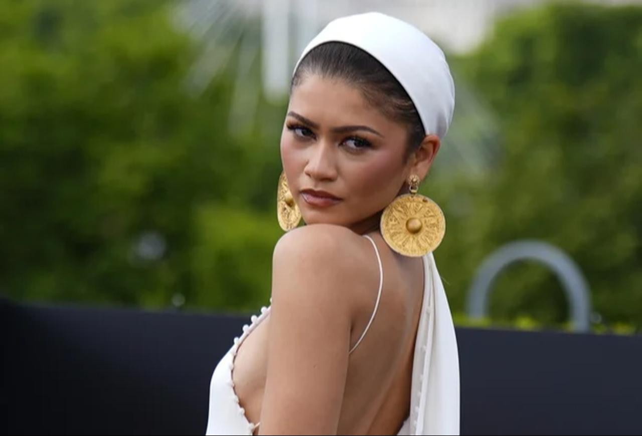 Zendaya wears a white Jacquemus gown and earrings incorporating ancient Iranian gold plaques during "The Odyssey" photocall in London, UK. (Photo via Instagram/@harpersbazaarus)