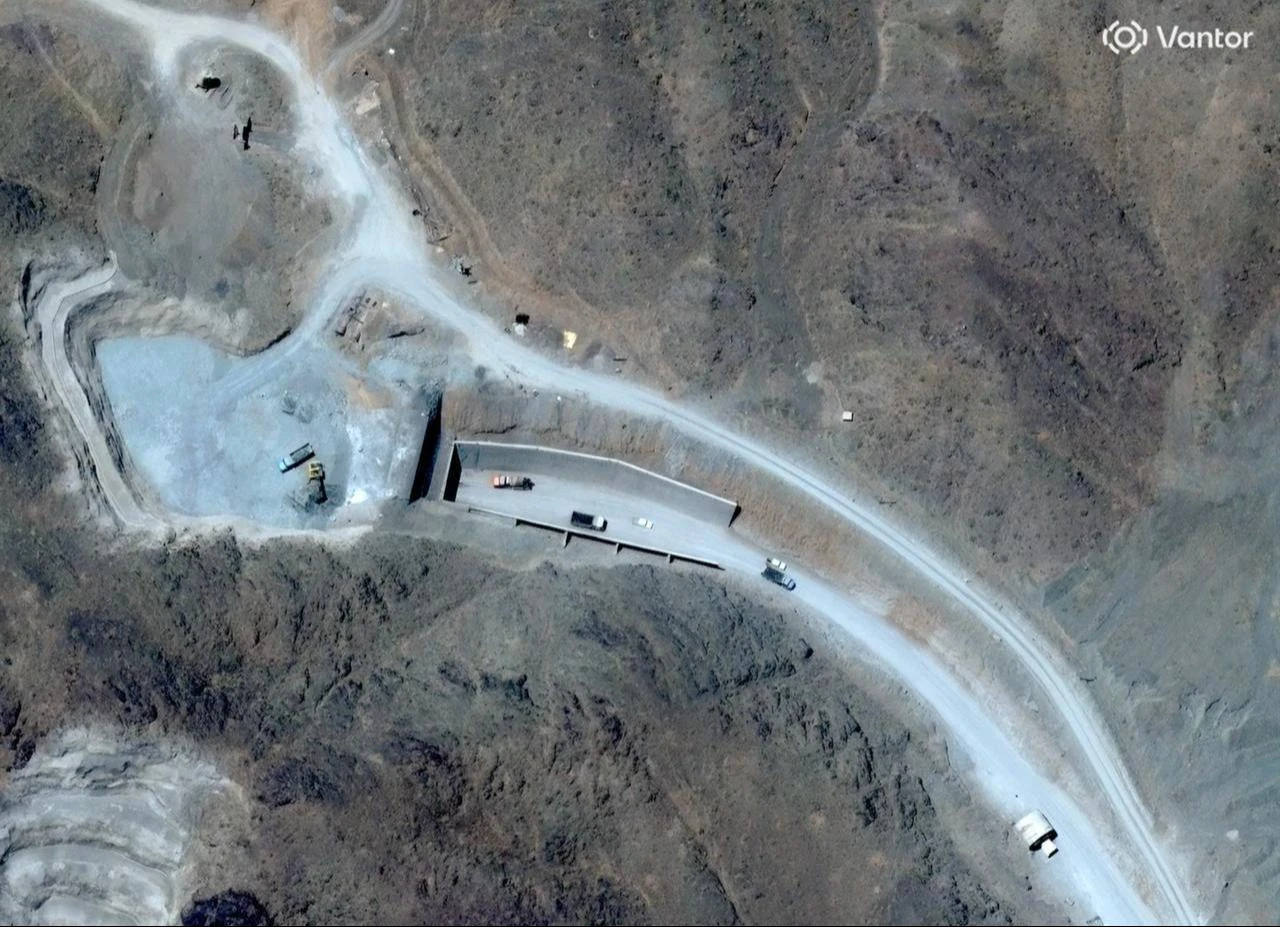 This handout satellite image shows vehicles at the western entrance of the Pickaxe Mountain tunnel complex adjacent to the Natanz Nuclear Facility near Natanz, Isfahan province, central Iran, June 21, 2026. (Photo by Satellite image ©2026 Vantor/AFP)