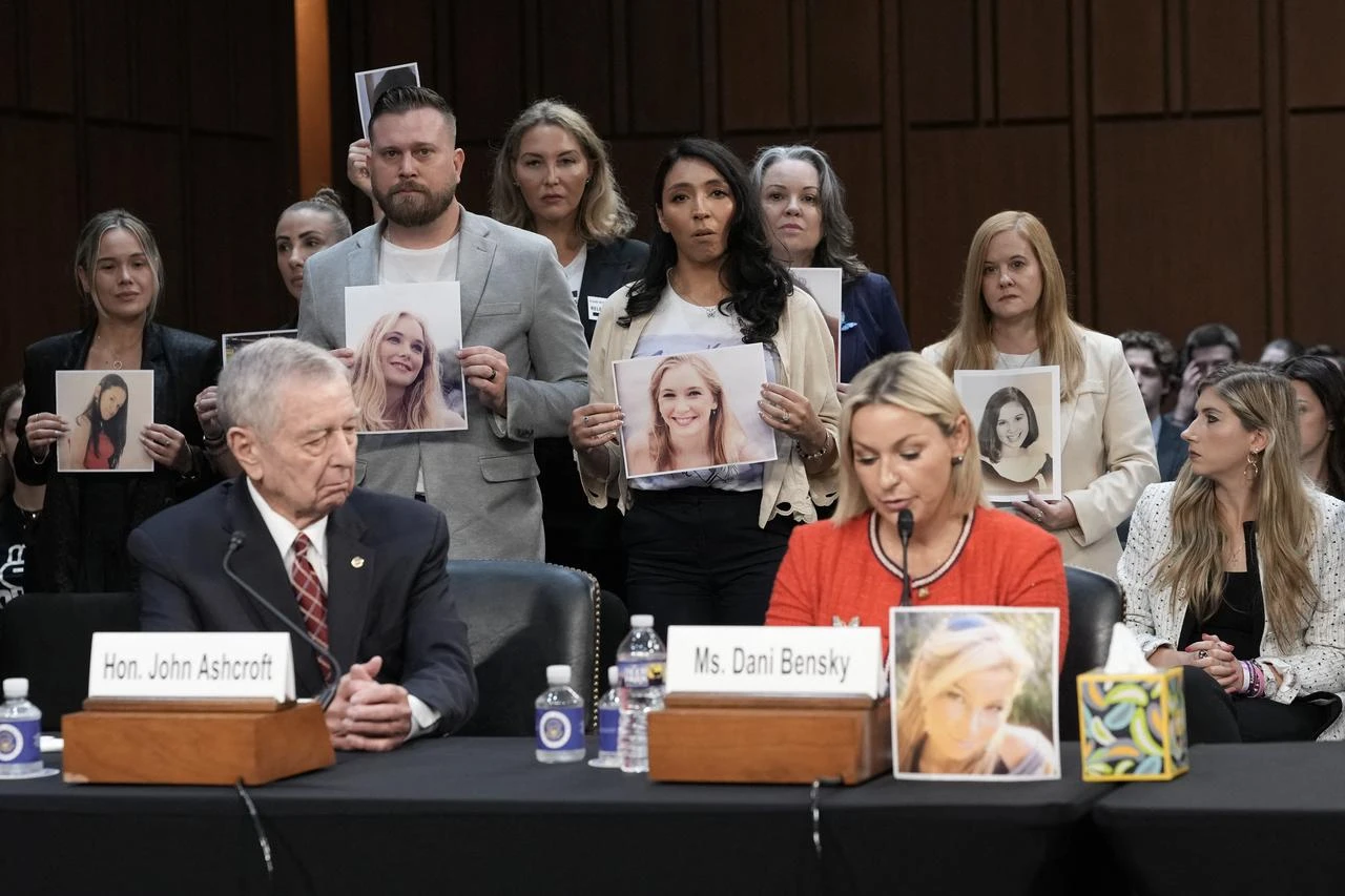 Jeffrey Epstein survivor Dani Bensky speaks beside former U.S. Attorney General John Ashcroft as survivors and family members hold childhood photographs during Todd Blanche’s Senate Judiciary Committee confirmation hearing on Capitol Hill in Washington, D.C., July 16, 2026. (AFP Photo)