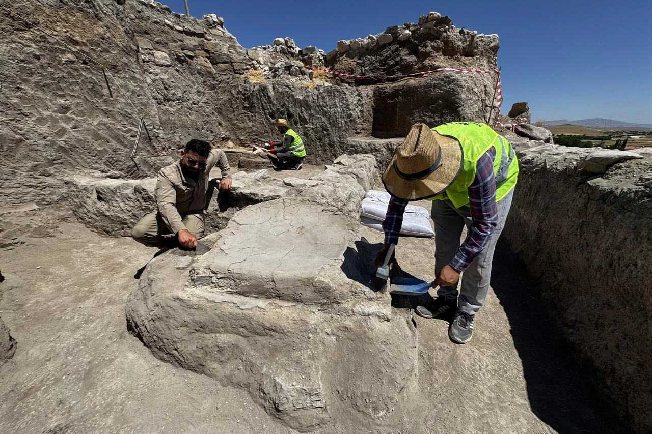 Archaeologists work around an ancient altar discovered within a 5,000-year-old temple area in Elazig, Türkiye, July 23, 2026. (AA Photo)
