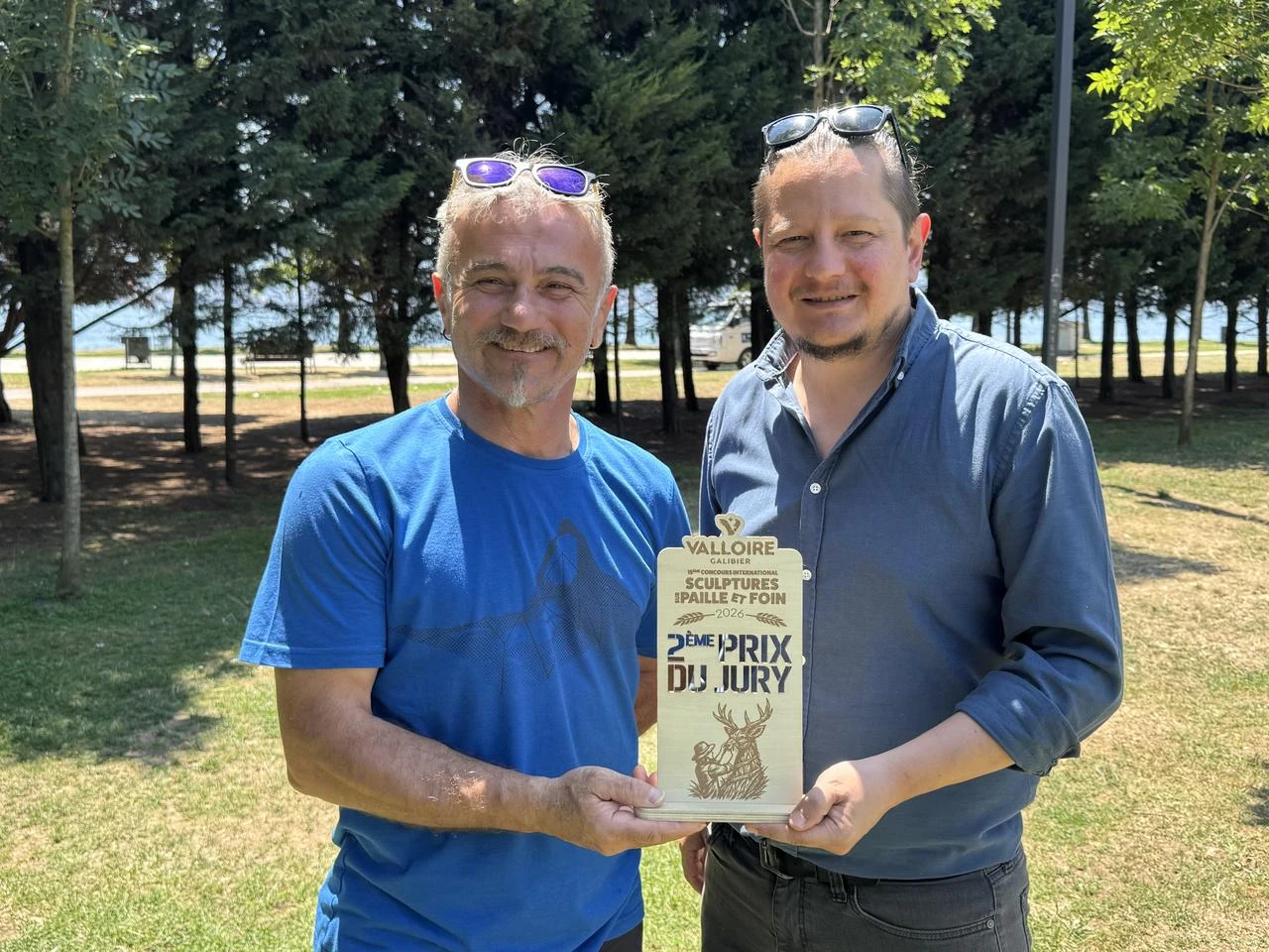 Turkish academics Ceyhun Konak and Bulent Cinar hold their second-place award from the Valloire International Straw and Hay Sculpture Competition in France. (AA Photo)