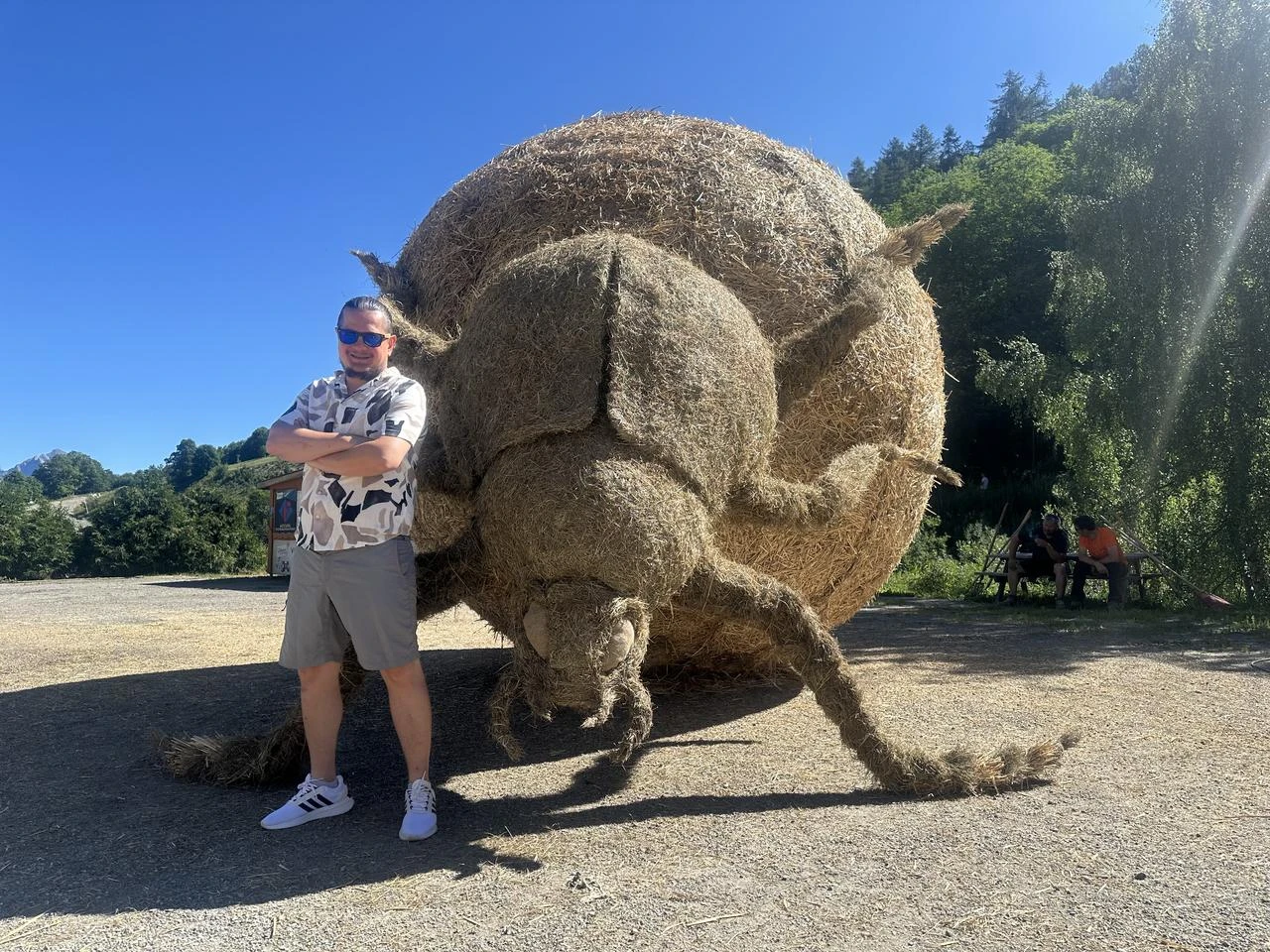 A member of the Turkish team poses beside “Dung Beetle / Scarabaeus Sacer,” a giant sculpture made from straw and hay in Valloire, France. (AA Photo)